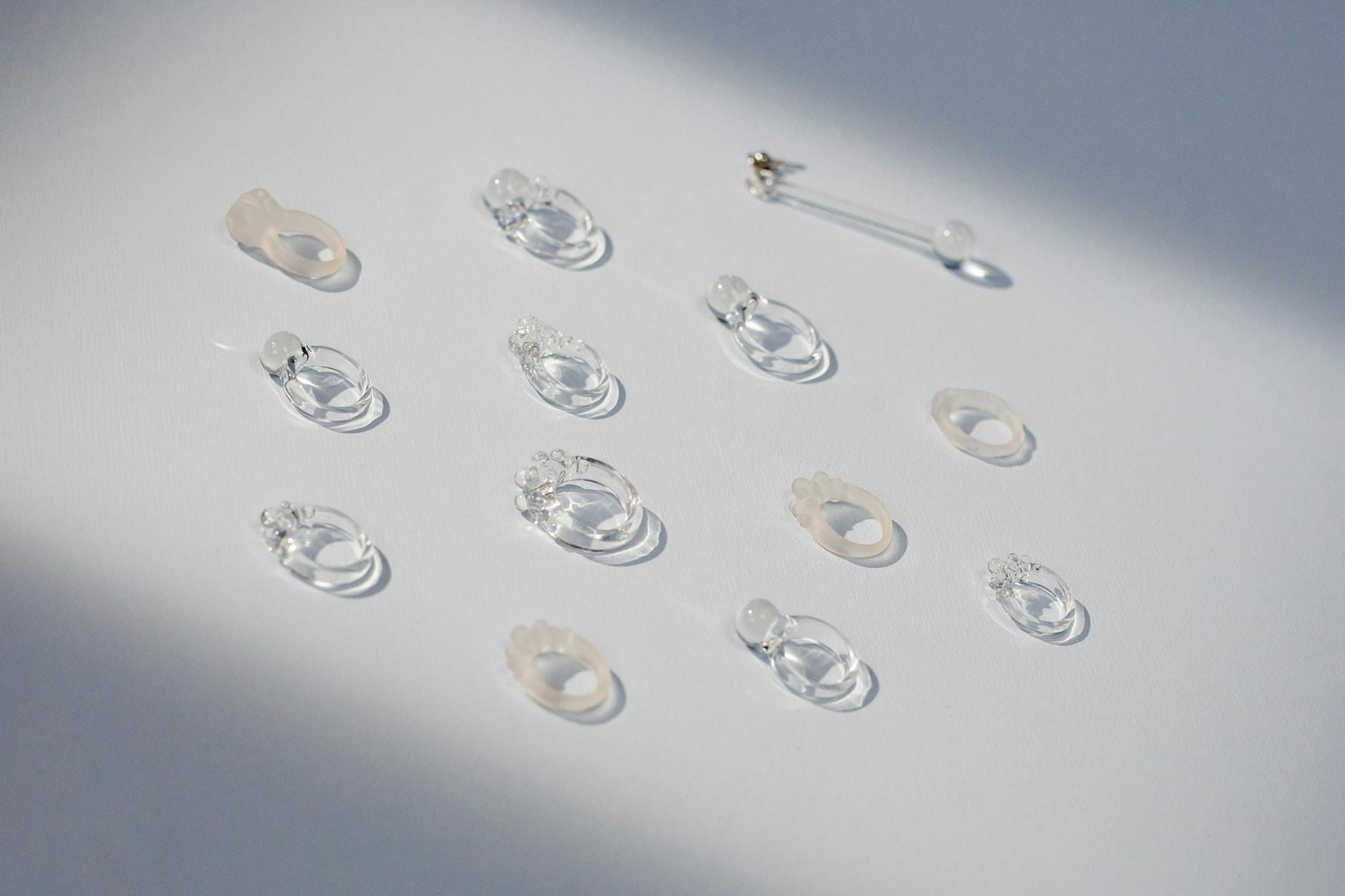 Przezroczyste pierścionki i biżuteria z kryształkami na białym tle