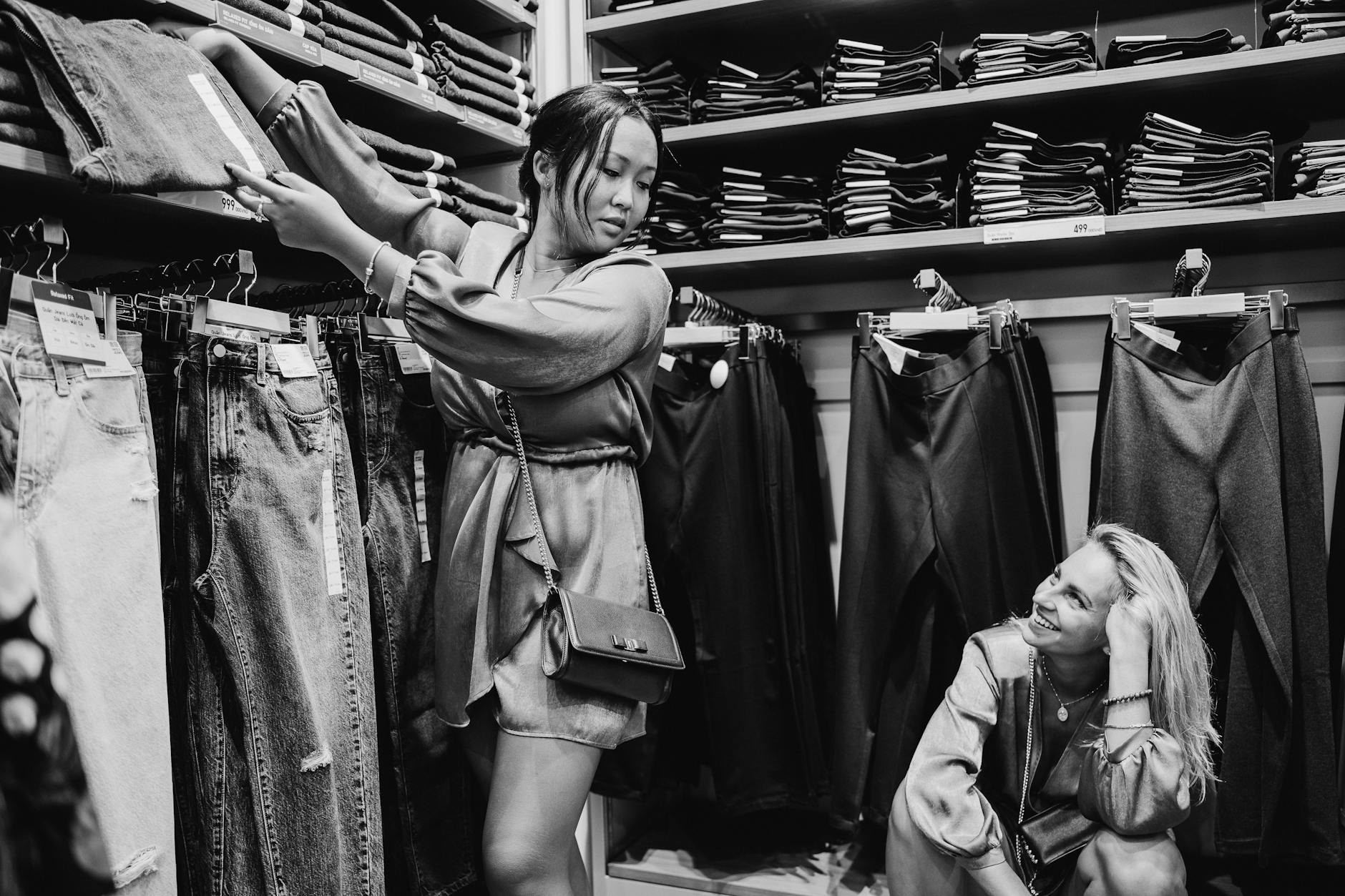 Dwie kobiety przymierzają jeansy w sklepie z odzieżą