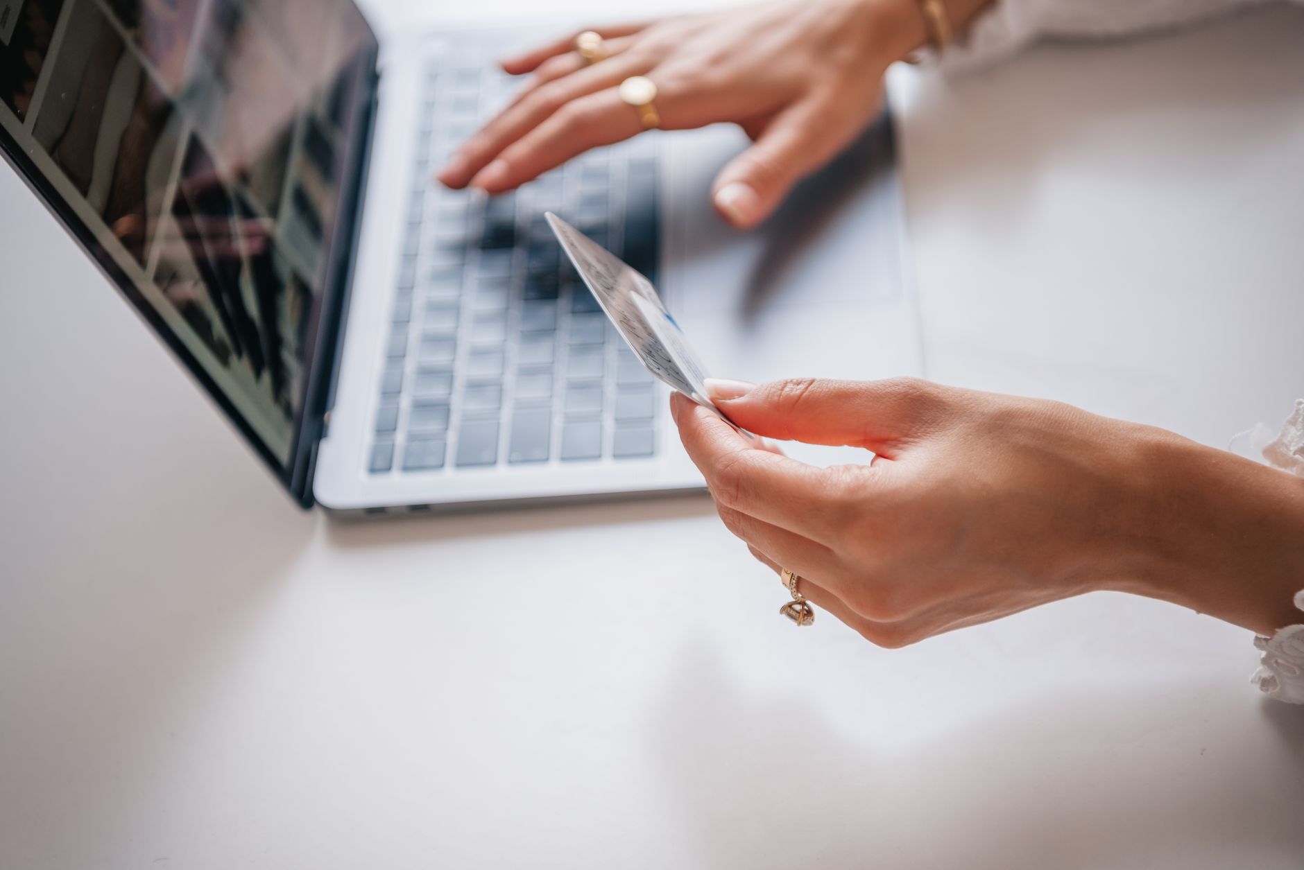 Jak robić zakupy biżuterii online i nie żałować: checklista Kobieta z kartą kredytową robi zakupy biżuterii online na laptopie